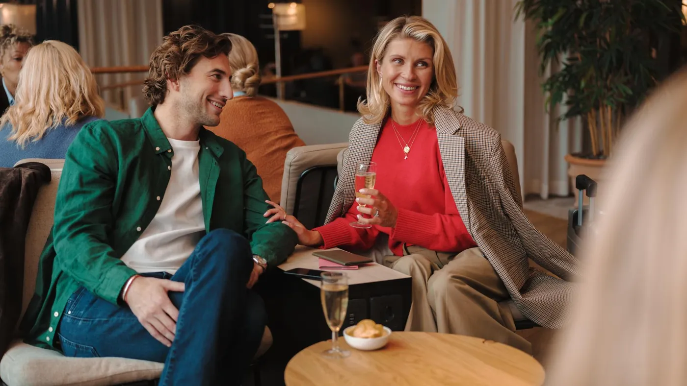 Två resenärer samtalar över ett glas i en SAS-lounge