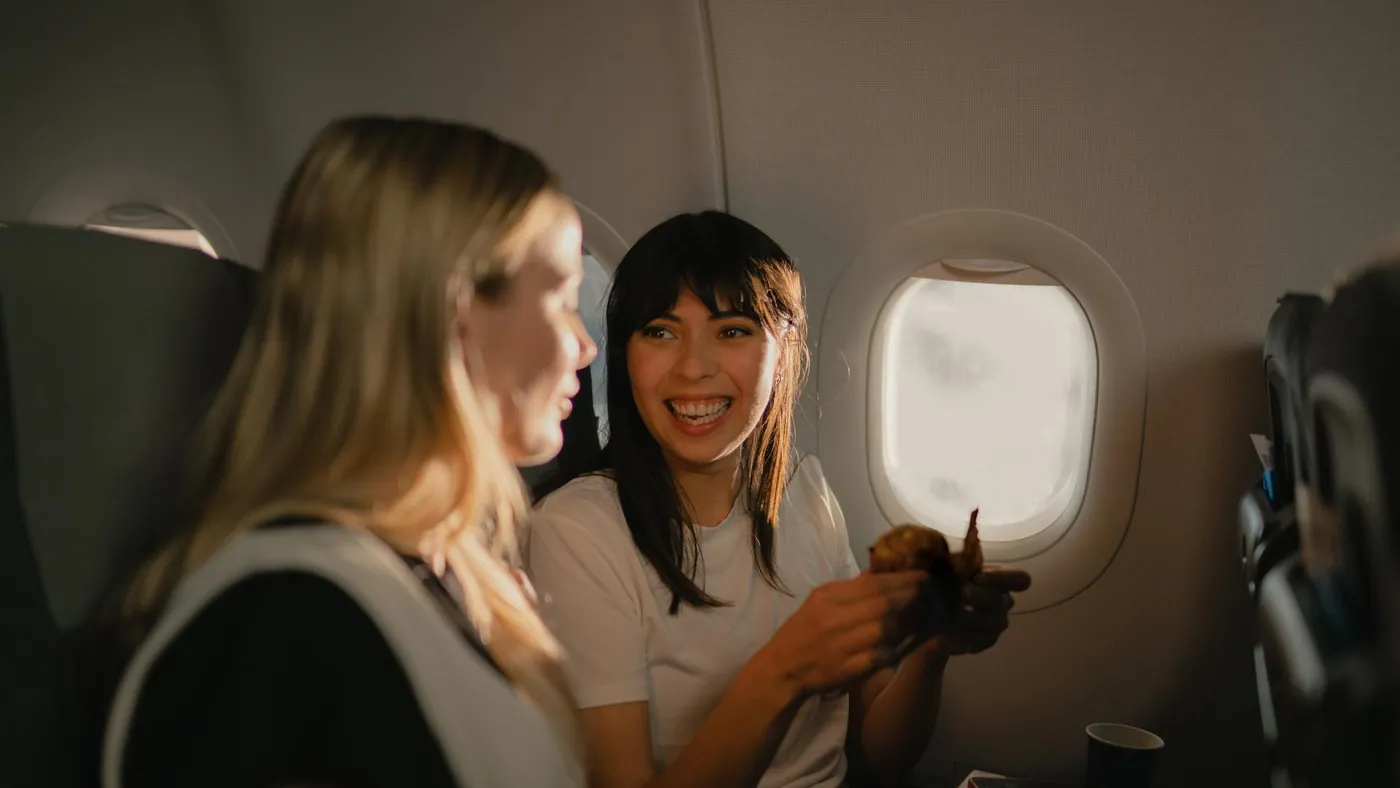 Två resenärer vid fönsterplatsen ombord på ett SAS-flyg
